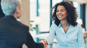 Photo of people shaking hands discussing the 4 Fundamental Skills to Increase Impact for Nonprofit Fundraising Leadership
