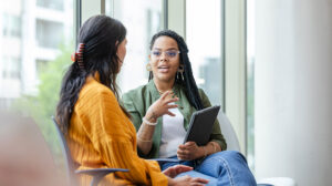 Manager discussing how to give feedback with another employee and discussing the different types of feedback